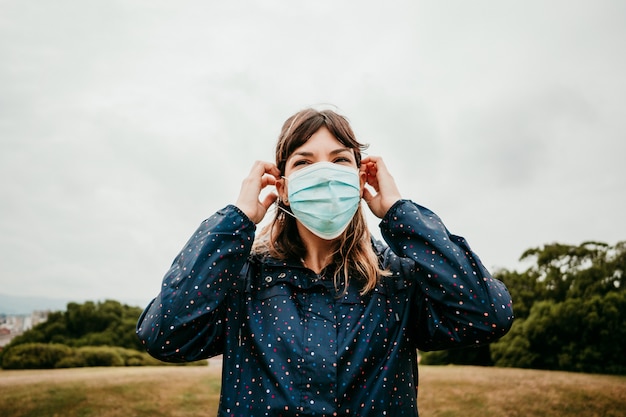 Young woman in a jacket with a medical mask