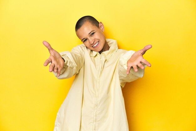 Young woman in jacket yellow studio backdrop feels confident giving a hug to the camera