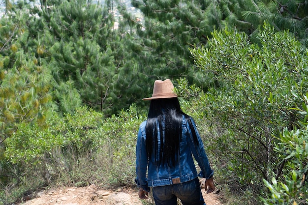 A young woman in a jeans jacket walking in the mountains