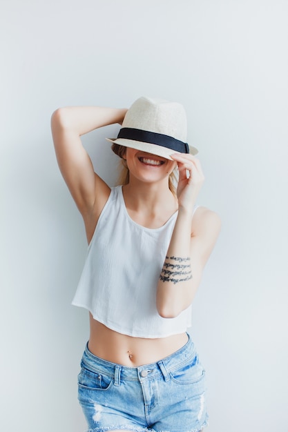 Young woman in jeans shorts and a hat