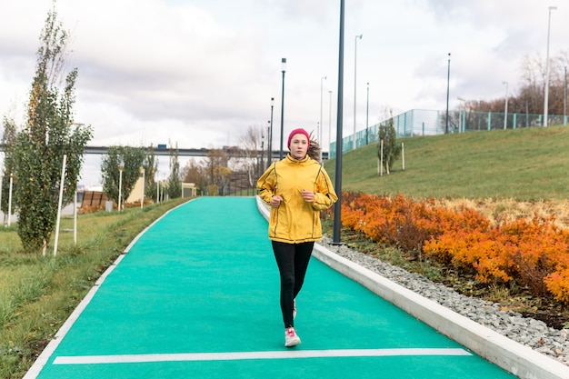 Young woman jogging in autumn park