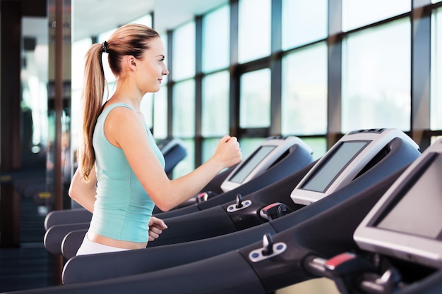 Young woman jogging at gym on treadmill