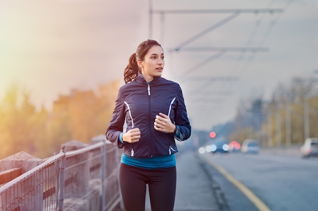 Young woman jogging on the street early in the morning