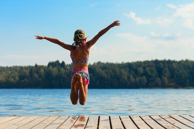 Young woman jumping into water