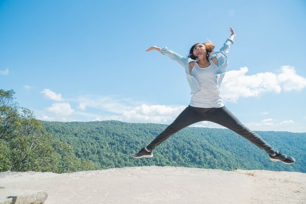 Young woman Jumping  at mountain view  for sun light