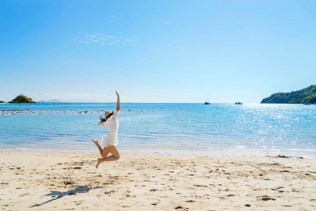 Young woman jumping on the tropical beach