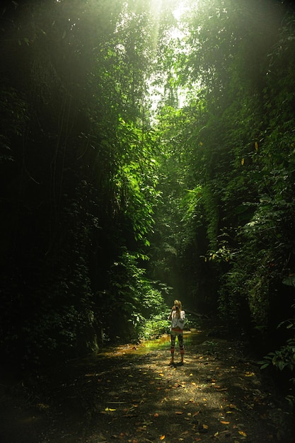 молодая женщина в джунглях на скале Бали Индонезия
