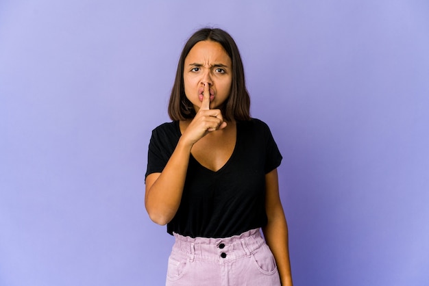 Young woman keeping a secret or asking for silence