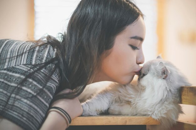 写真 家で猫にキスする若い女性