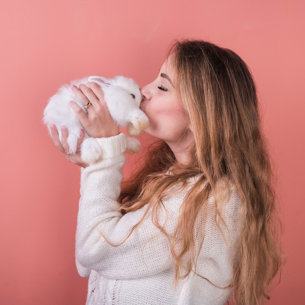 若い女性がウサギにキス