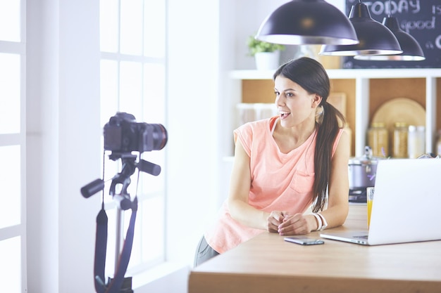 Young woman in kitchen with laptop computer looking recipes smiling Food blogger concept