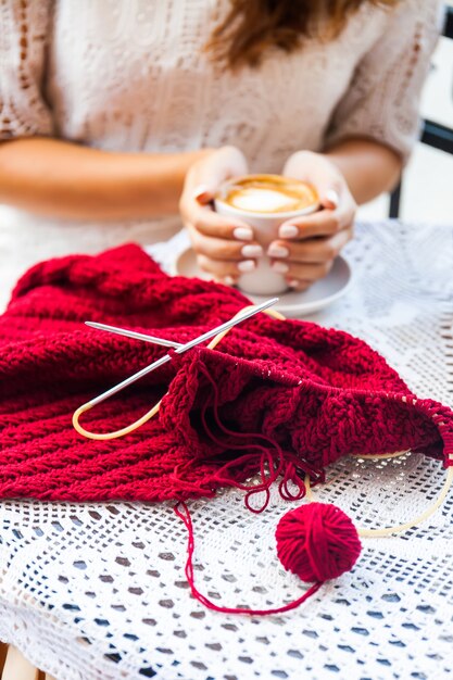 Young Woman knitting on terrace in Cafe