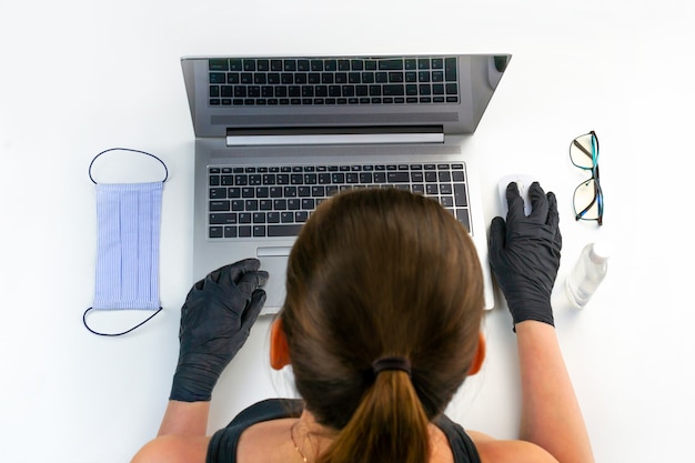 Young woman in latex gloves is working on computer