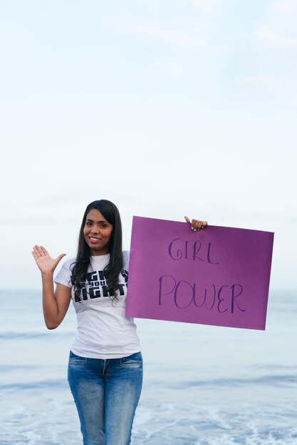 Young woman laughing holding a banner during a protest