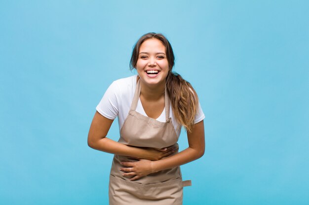 Young woman laughing out loud at some hilarious joke, feeling happy and cheerful, having fun