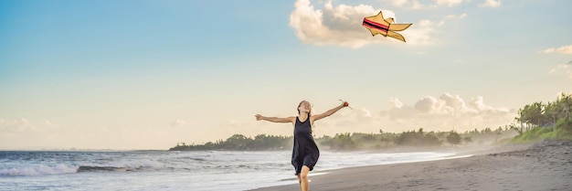 A young woman launches a kite on the beach dream aspirations future plans banner long format