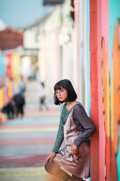 Young woman leaning on graffiti wall