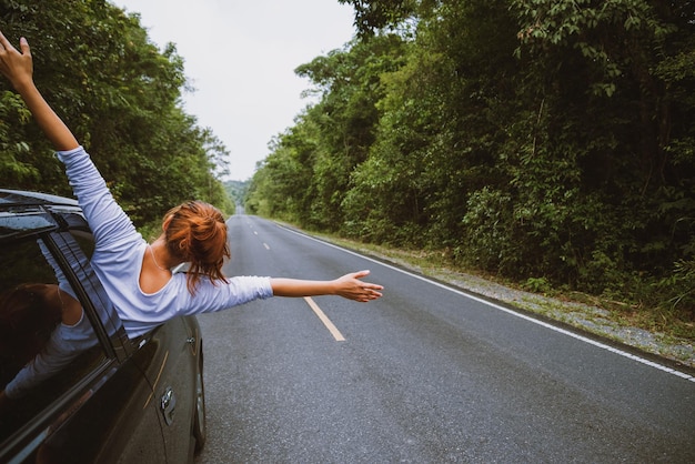 Photo young woman leaning out of car window