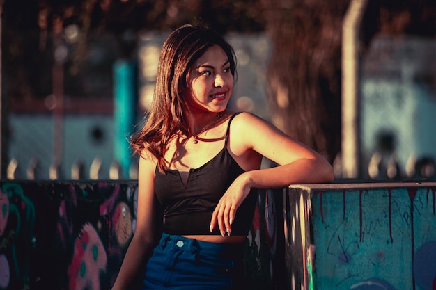 Young woman leaning on a wall with graffiti