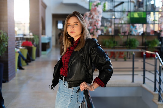 young woman in leather jacket in a shopping center