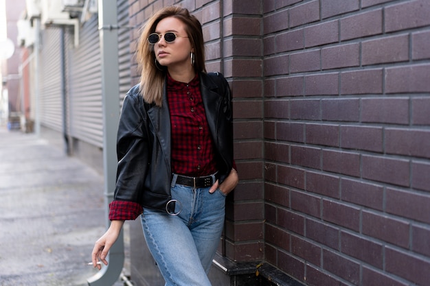 young woman in leather jacket smoking