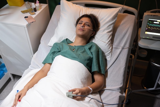 Young woman lies in a hospital bed after a severe accident she is resting surrounded by medical