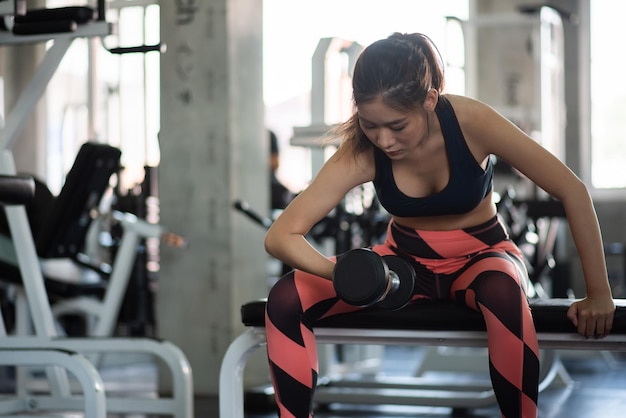 Foto giovane donna che solleva i manubri in palestra