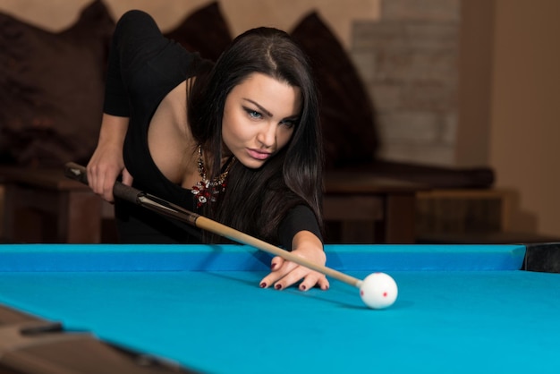 Young Woman Lining To Hit Ball On Pool Table