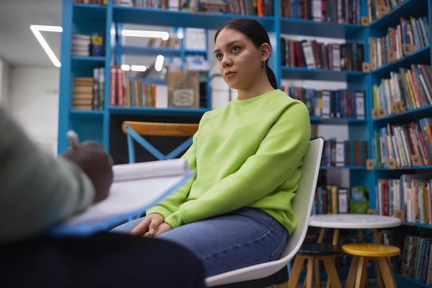 Young woman listening to male therapist during psychology consultation