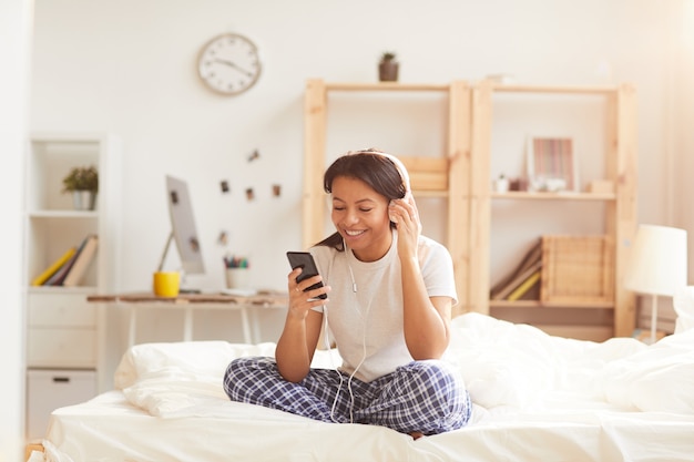 Young Woman Listening to Music on Bed