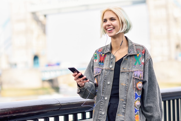 Young woman listening to the music in city