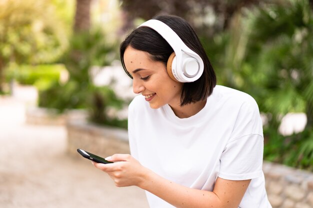 Young woman listening music at outdoors