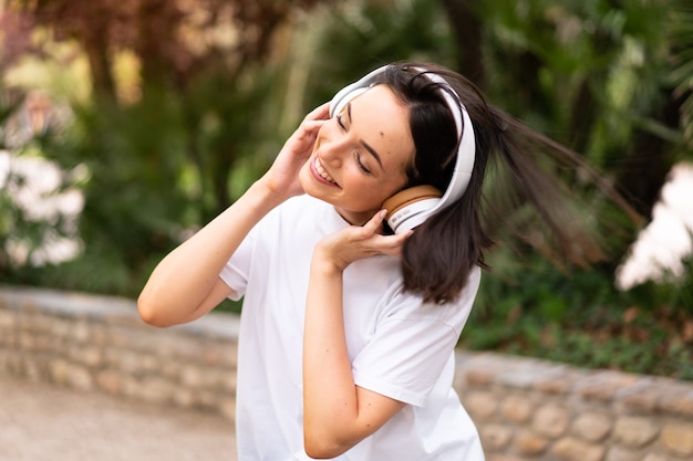 屋外で音楽を聴く若い女性