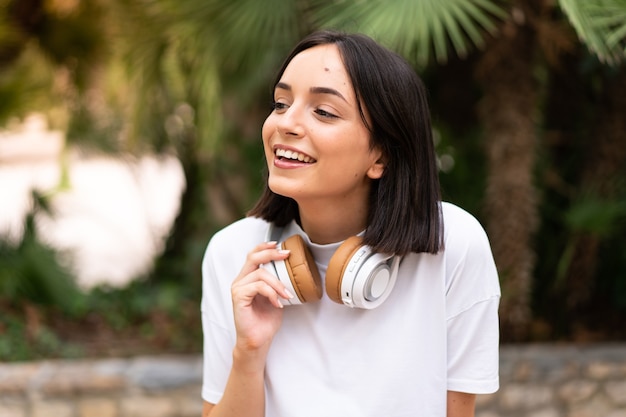 屋外で音楽を聴く若い女性