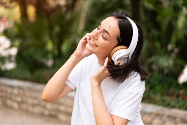 屋外で音楽を聴く若い女性