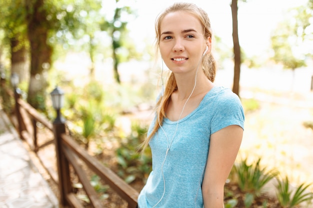 Young woman listens to music in earphones during training