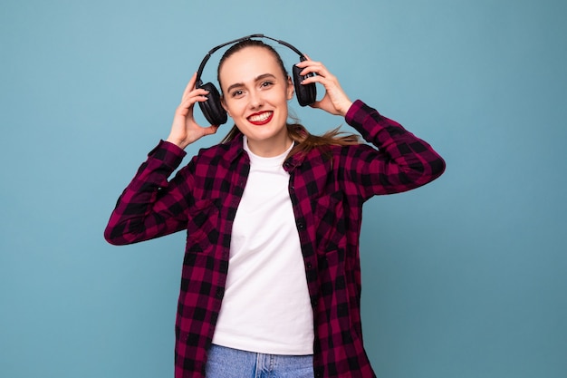 A young woman listens to music with headphones in a good mood
