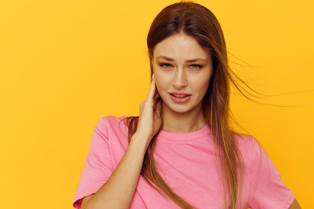 ピンクのTシャツの若い女性の長いヘアスタイルライフスタイルは変更されていません