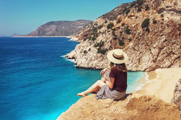 Young woman look out over beautiful Kaputas beach, travel Lycia coast on a bright summer day during vacation