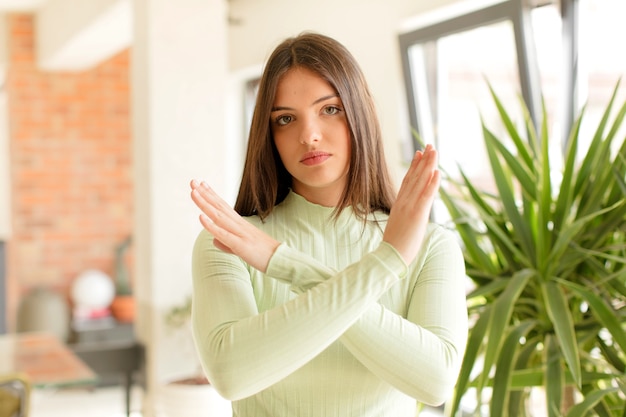 イライラしてあなたの態度にうんざりしている若い女性は、十分な手が前に交差して停止するように言っている