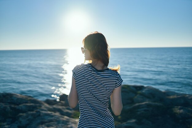 Фото Молодая женщина смотрит на море на фоне неба