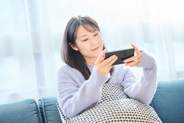 Фото Молодая женщина смотрит на экран смартфона