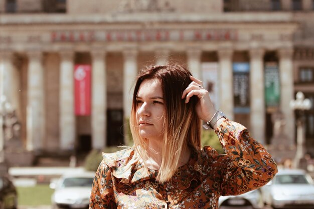 Foto giovane donna che distoglie lo sguardo dall'edificio