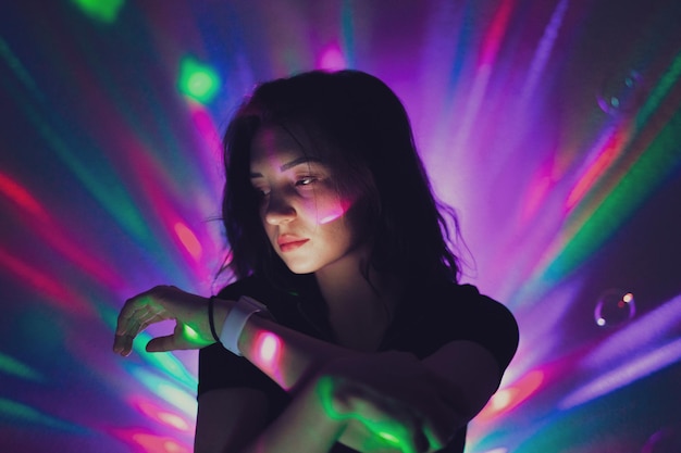 Photo young woman looking away against illuminated lights