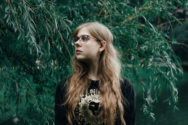 Photo young woman looking away against plants