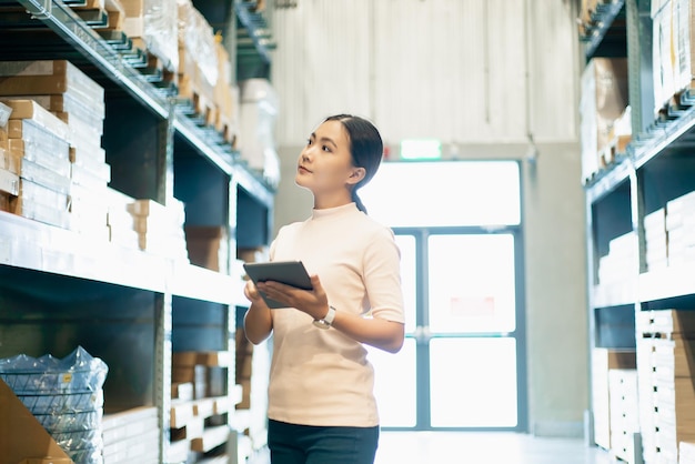 店に立っている間にデジタルタブレットを握っている若い女性