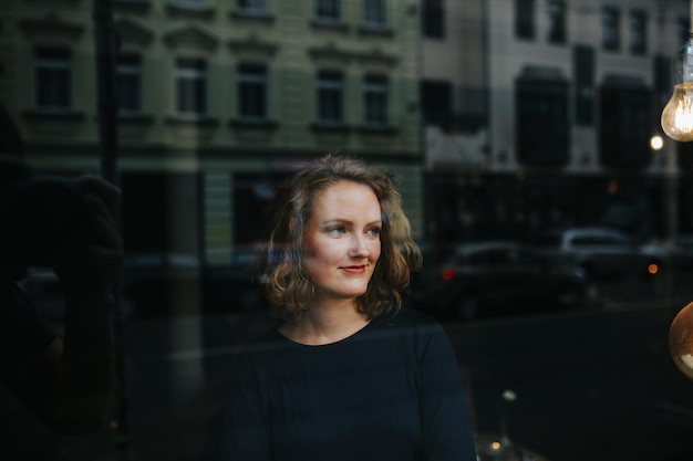 Photo young woman looking away seen through window