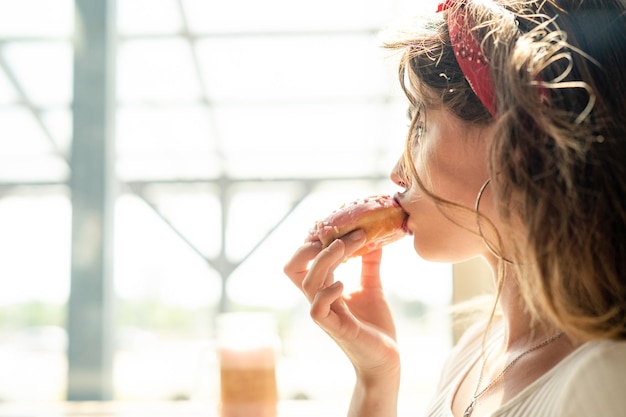 young woman looking away while eating food