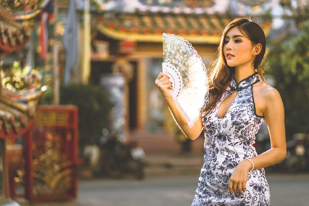 Photo young woman looking away while holding hand fan