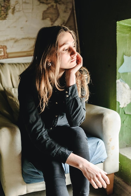Young woman looking away while sitting at home